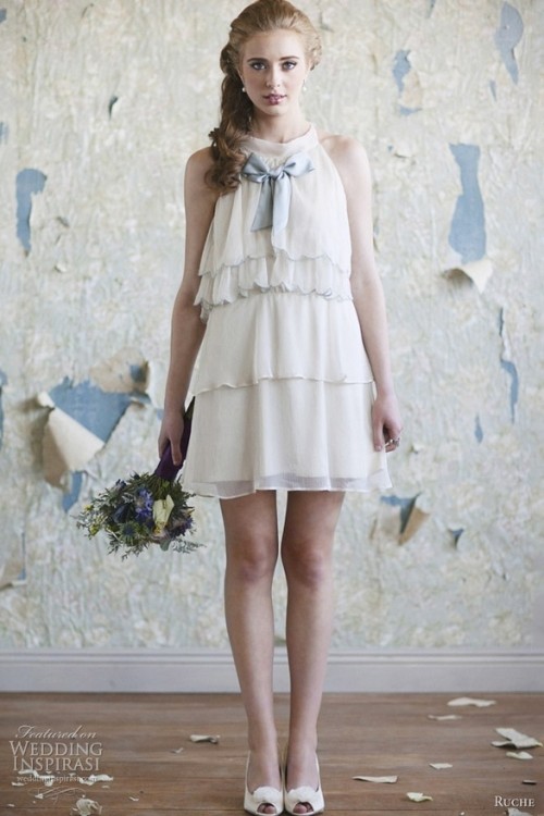 a short A-line layered wedding dress with a halter neckline, a blue bow a nd peep toe shoes for a vintage-inspired outfit
