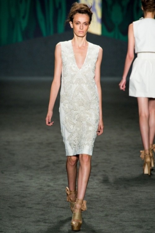a straight sleeveless wedding dress with appliques and embroidery, a deep V-neckline and catchy shoes