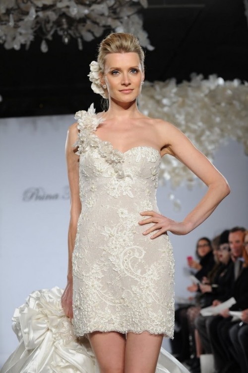 an ivory lace short wedding dress with a floral strap on one shoulder and fabric blooms in the hairstyle