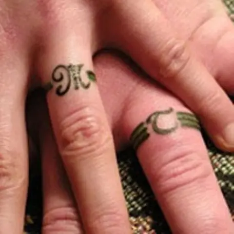 Husband and wife tattoos with initials and bands is a catchy idea