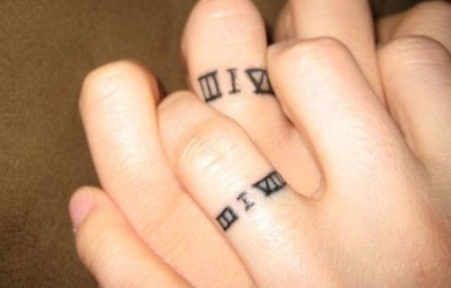 Ring tattoos with a wedding date done with Roman numbers