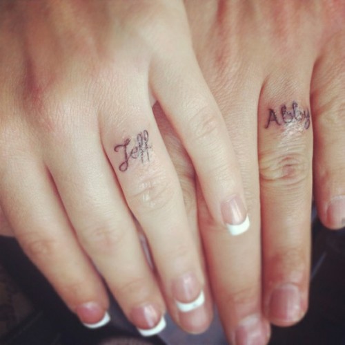 Partner names tattooed in cursive is a classic idea for wedding rings