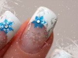 a French manicure with silver glitter and blue snowflakes plus silver patterns for a snow-loving bride