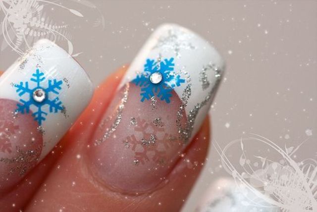 a French manicure with silver glitter and blue snowflakes plus silver patterns for a snow loving bride
