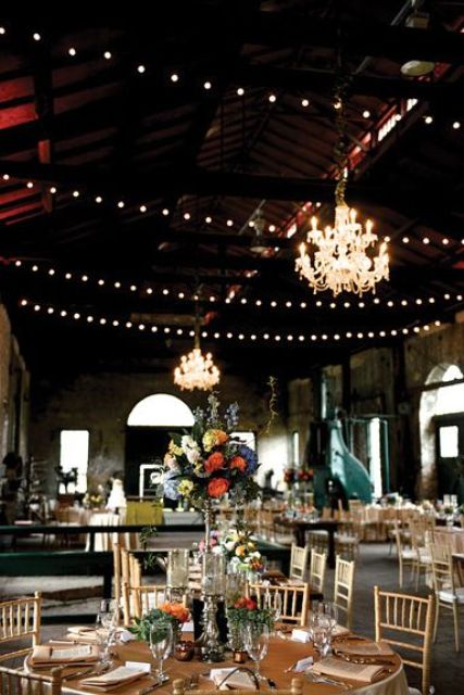 string lights and chandeliers are an elegant combo for a barn venue or some other wedding venue