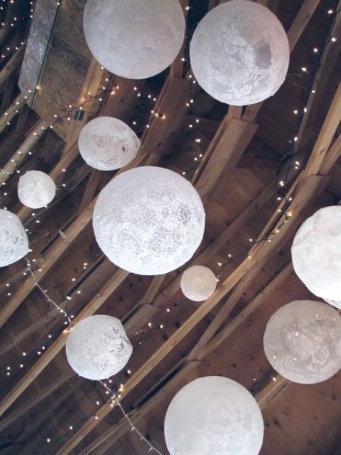 string lights paired with doily sphere pendant lamps are amazing for a wedding venue, whether it's a barn or not