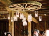 a rustic wedding chandelier of a large wheel and glass jars suspended to it is a lovely idea for a rustic wedding