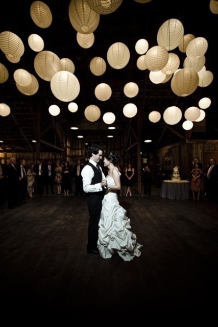 a barn venue lit up with lots of paper pendant lamps is a gorgeous idea that won't break the bank and will keep your budget up