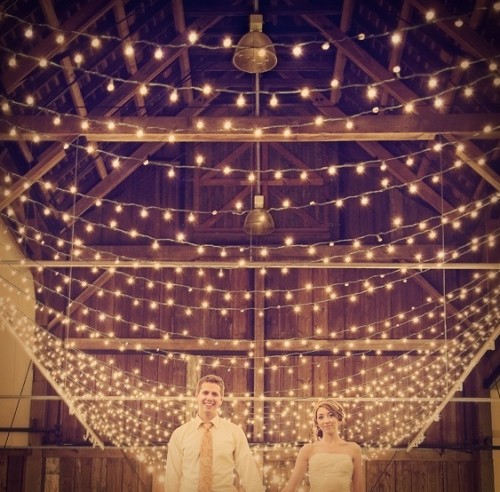 string lights paired with usual metal pendant lamps will make your barn wedding venue bright and welcoming