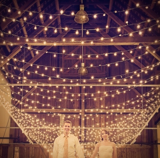 string lights paired with usual metal pendant lamps will make your barn wedding venue bright and welcoming