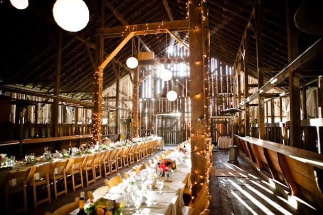 lights covering pillars and paper pendant lamps are a nice pair for a barn wedding venue