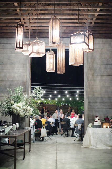 beautiful metal and glass pendant lamps paired with string lights are amazing for any wedding venue, not only a barn