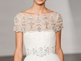 an A-line draped wedding dress with a beaded waistline and a fully embellished neckline and cap sleeves