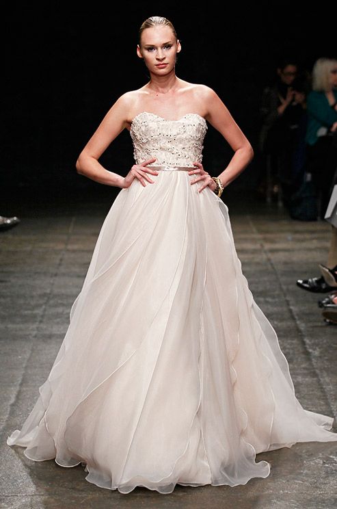 a strapless wedding ballgown with a beaded bodice and a tulle skirt, a silk sash and a train for a formal and refined wedding