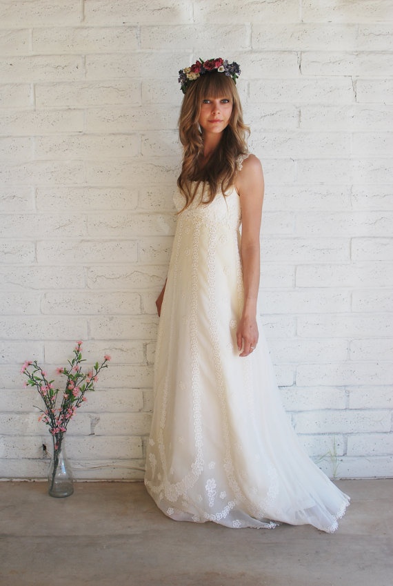 A lace A line wedding dress with straps and a train and a floral crown to look super romantic
