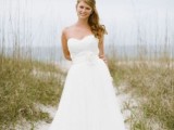 a strapless A-line wedding dress with a sash and a fabric flower is a beautiful and romantic formal wedding gown