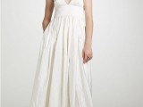 a simple and casual A-line plain wedding gown with a V-neckline and spaghetti straps for a casual beach wedding