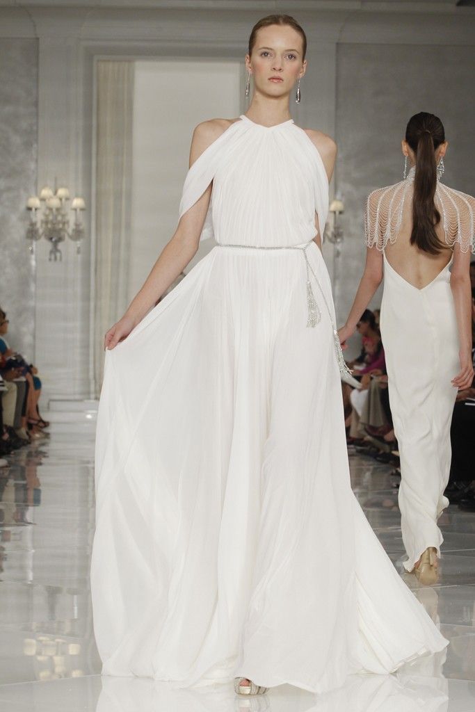A flowy and airy halter neckline wedding dress with draperies and a silver sash with tassels for a minimalist bride