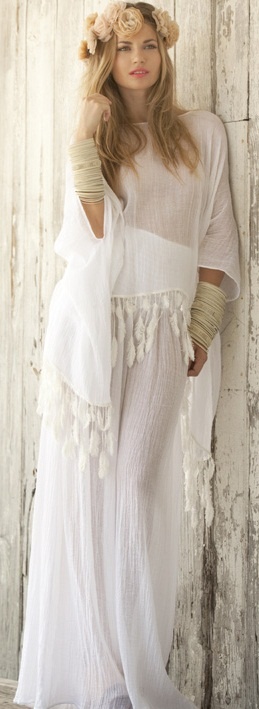a gypsy-style flowy wedding gown with wide sleeves and tassels and multiple bracelets for a flowy beach look