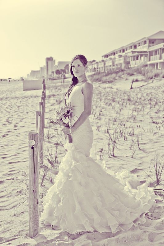 A sexy mermaid draped wedding dress with a ruffle tail and spaghetti straps is a statement idea