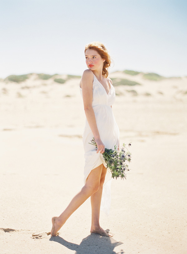 A simple modern plain short wedding dress with a deep neckline and spaghetti straps for a modern beach bride