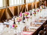 a bright barn wedding tablescape with a burlap table runner, colorful blooms and greenery, colorful napkins for a summer wedding