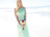 a light green maxi bridesmaid dress with embellishments on the shoulder and waist for a pastel beach wedding