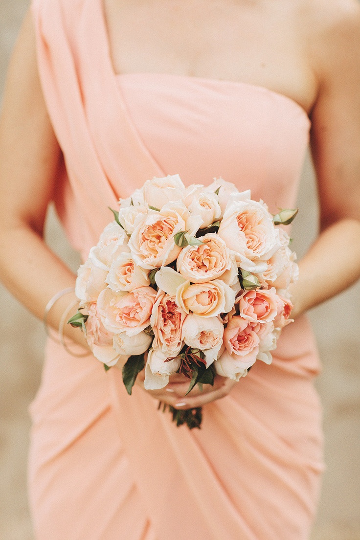 A draped peachy pink bridesmaid dress with a strap on one shoulder is very lovely and chic