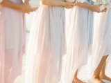 matching strapless blush and off-white draped asymmetrical bridesmaid dresses for a chic and stylish beach wedding