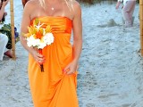 an orange strapless maxi bridesmaid dress with a draped bodice for a bright beach wedding