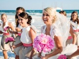 chic bridesmaid dresses with white one shoulder bodices and tan skirts plus pink sashes