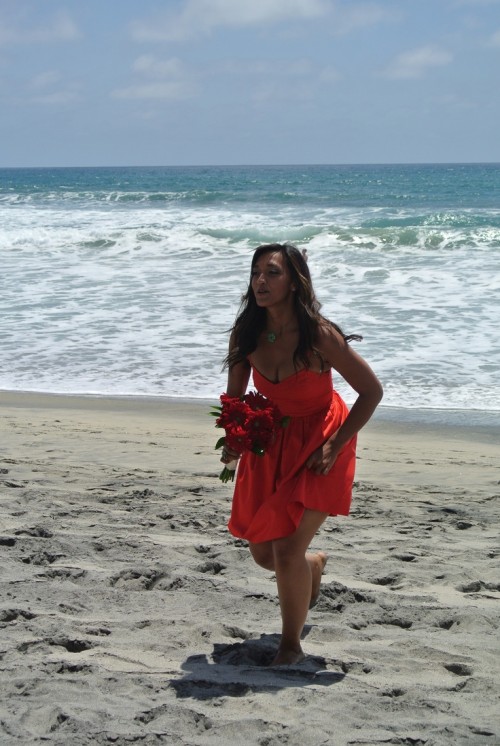 a red strapless A-line short bridesmaid dress with a draped bodice is a bold solution for a beach wedding
