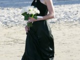 a black silk maxi dress with a train and a halter neckline is a refined and stylish piece for a modern beach wedding