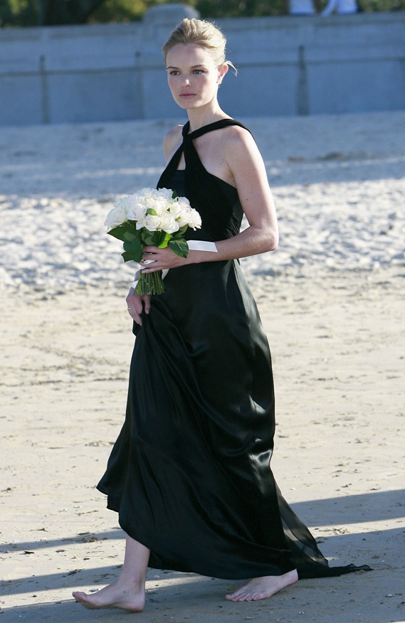 A black silk maxi dress with a train and a halter neckline is a refined and stylish piece for a modern beach wedding
