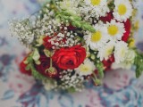 a bright summer wedding bouquet of hot red ranunculus, white chamomiles, baby’s breath and greenery for a relaxed summer wedding