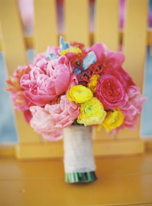 a bright wedding bouquet of pink peonies, yellow ranunculus and pale foliage is amazing for a bright summer or spring wedding