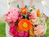 a colorful wedding bouquet of hot and light pink blooms and orange ones plus greenery is an amazing idea for a bold summer wedding