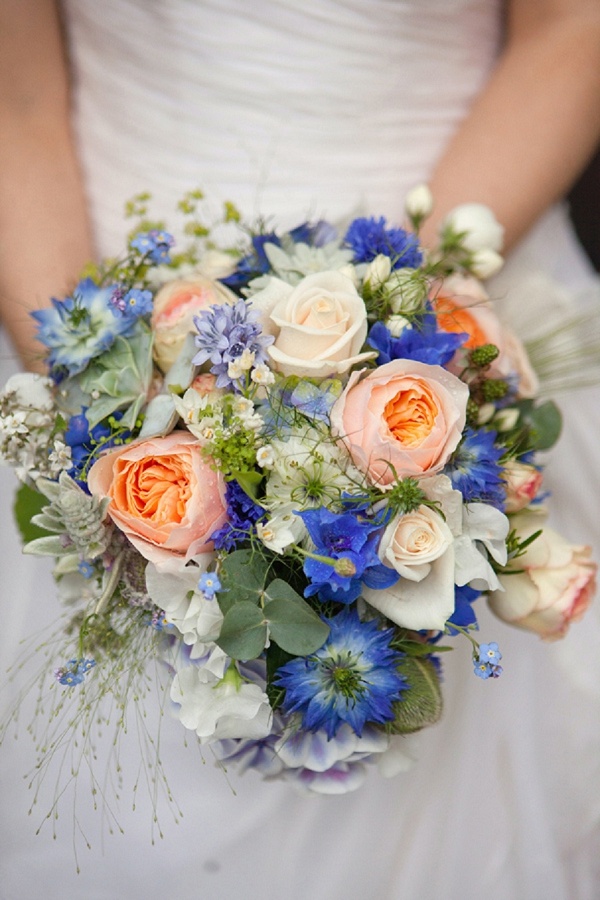 A lovely and bright summer wedding bouquet of white, peachy pink and blue blooms and greenery is a cool idea for summer