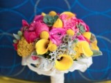 a colorful summer wedding bouquet of yellow cllas, pink ranunculus, succulents and pale greenery