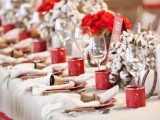 a cozy and fun Christmas tablescape with red bloom and cotton centerpieces, red signs and large bells for a bold look