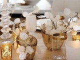 a white and gold Christmas tablescape with lunaria centerpieces, mercury glass candleholders, candles and white porcelain