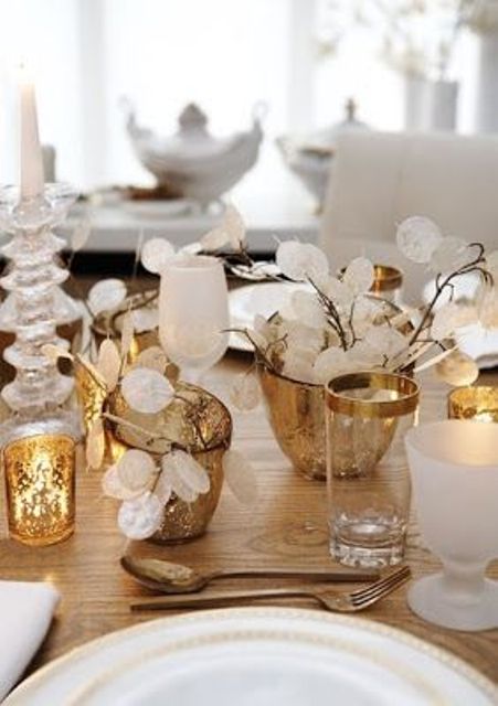 a white and gold Christmas tablescape with lunaria centerpieces, mercury glass candleholders, candles and white porcelain