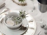 a neutral Christmas tablescape with thostles, glitter ornaments, grey and sivler plates, sheer white ornaments with names