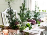 a natural Christmas tablescape with Christmas trees, a box centerpiece with veggies and greenery, metallic ornaments and candles, pinecones and evergreens in cups