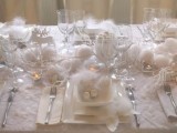 a pure white Christmas table with felt snowballs, feathers, ornaments, deer figurines and all-white everything