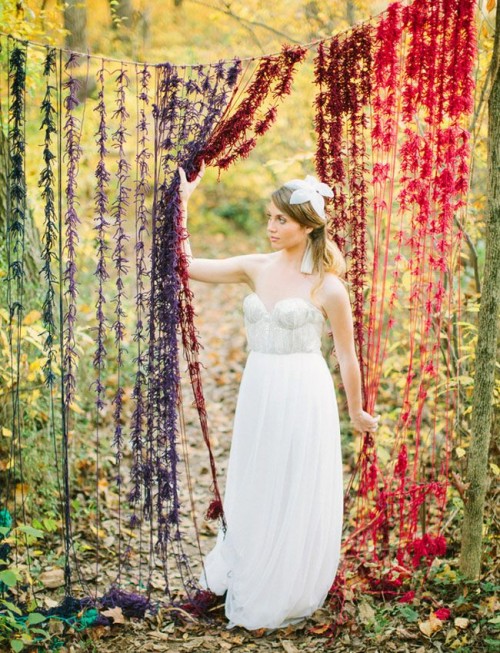 an ombre colorful fringe fall wedding backdrop is done in bold shades to embrace the season and can be easily DIYed