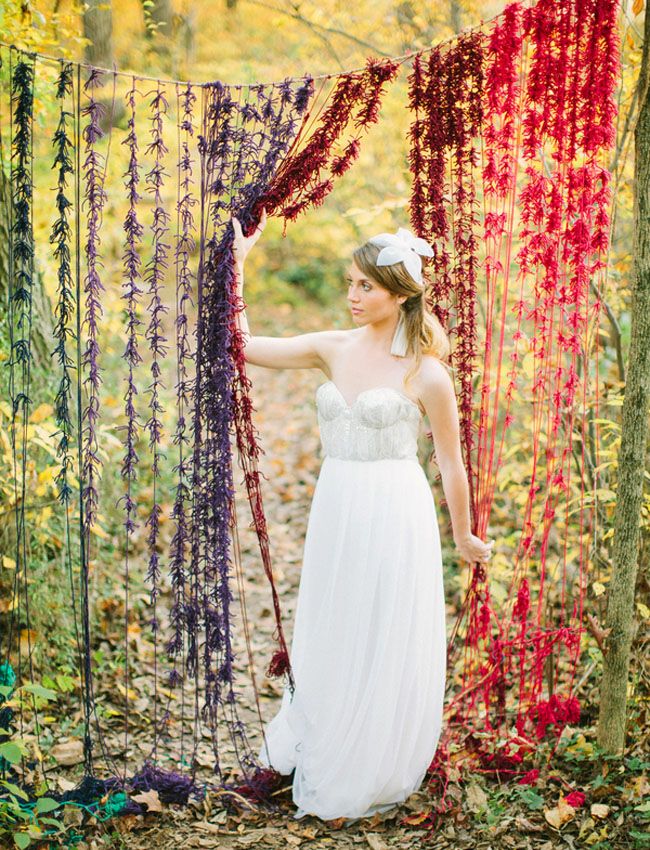 An ombre colorful fringe fall wedding backdrop is done in bold shades to embrace the season and can be easily DIYed