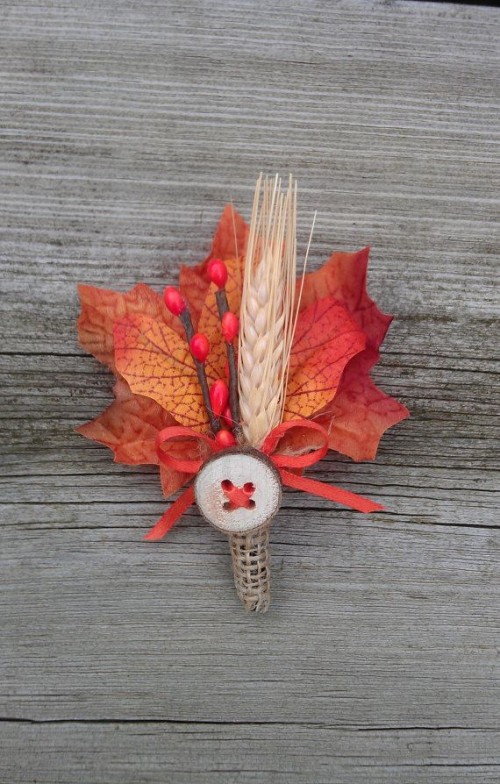 a bright fall wedding boutonniere with bold leaves, faux berries, a spike and a button plus some twine