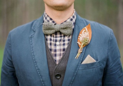 a bright fall wedding boutonniere with a bold and large leaf, some blooms and greenery for a vintage-inspired rustic wedding