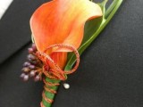 a bright fall wedding boutonniere with a single orange calla and berries plus some leaves is a cool idea for a modern groom